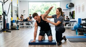 A professional, high-resolution editorial shot of a physiotherapist guiding an athlete through dynam